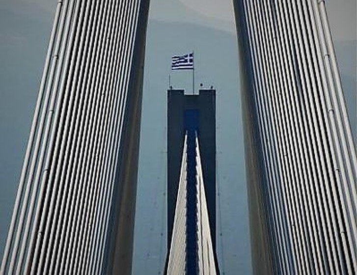 Η ελληνική σημαία υψώνεται στη Γέφυρα Ρίου – Αντιρρίου ενώ ακούγεται ο Εθνικός Ύμνος.